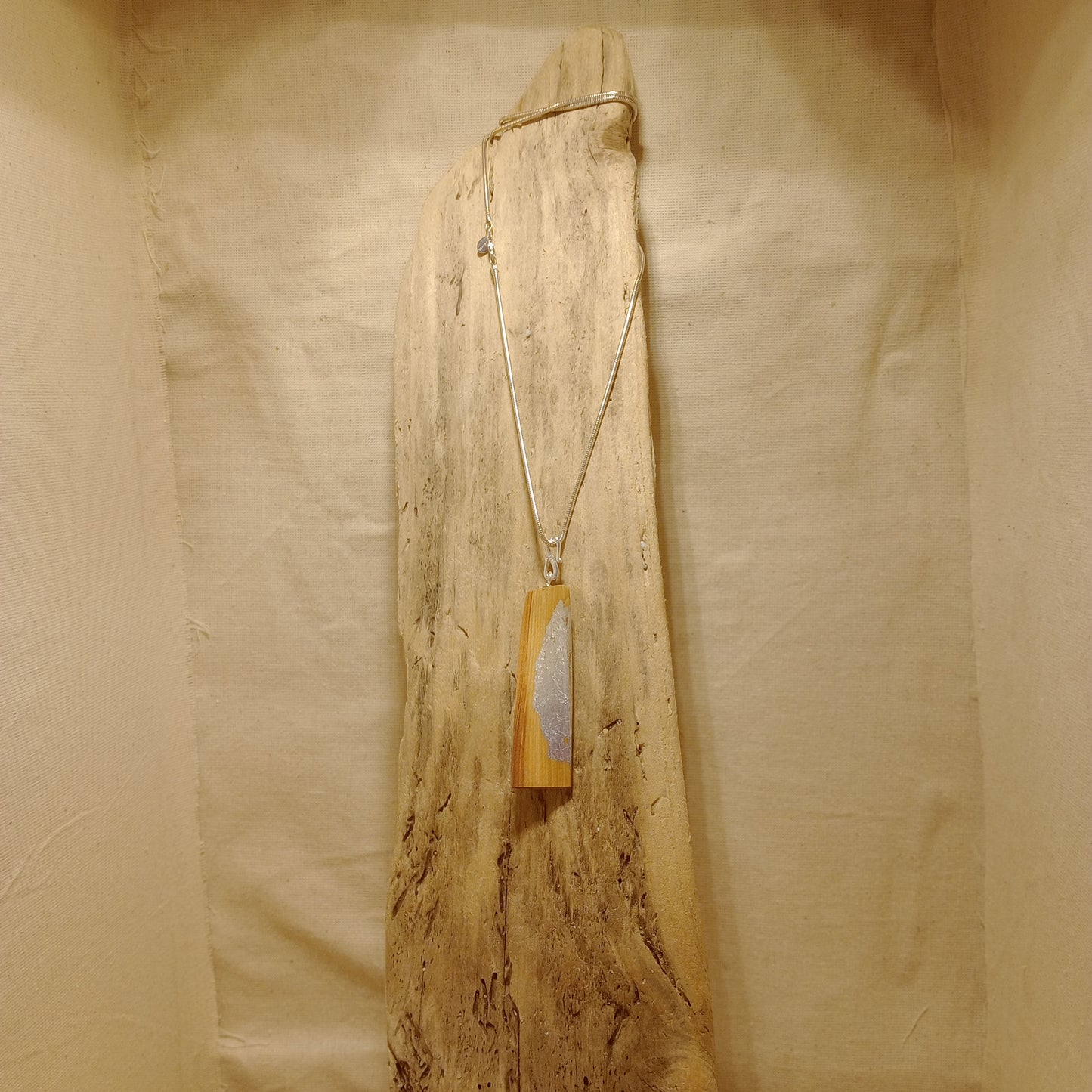 The Twist steam bent yew pendant with silver leaf on sterling silver snake chain
